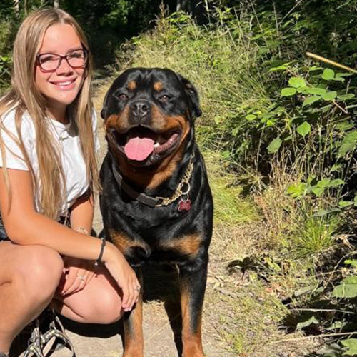 Regan is posing with a rottweiler dog.